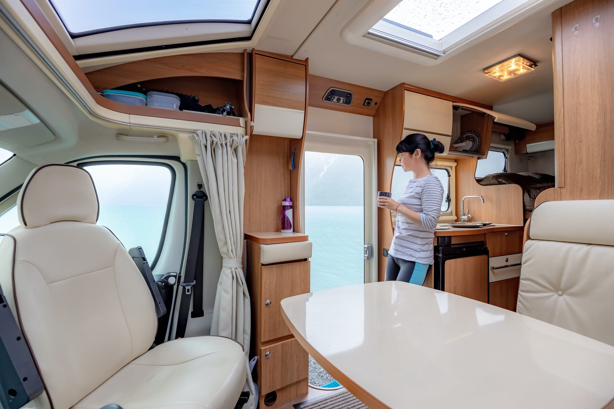 Woman in the interior of a camper RV motorhome with a cup of cof