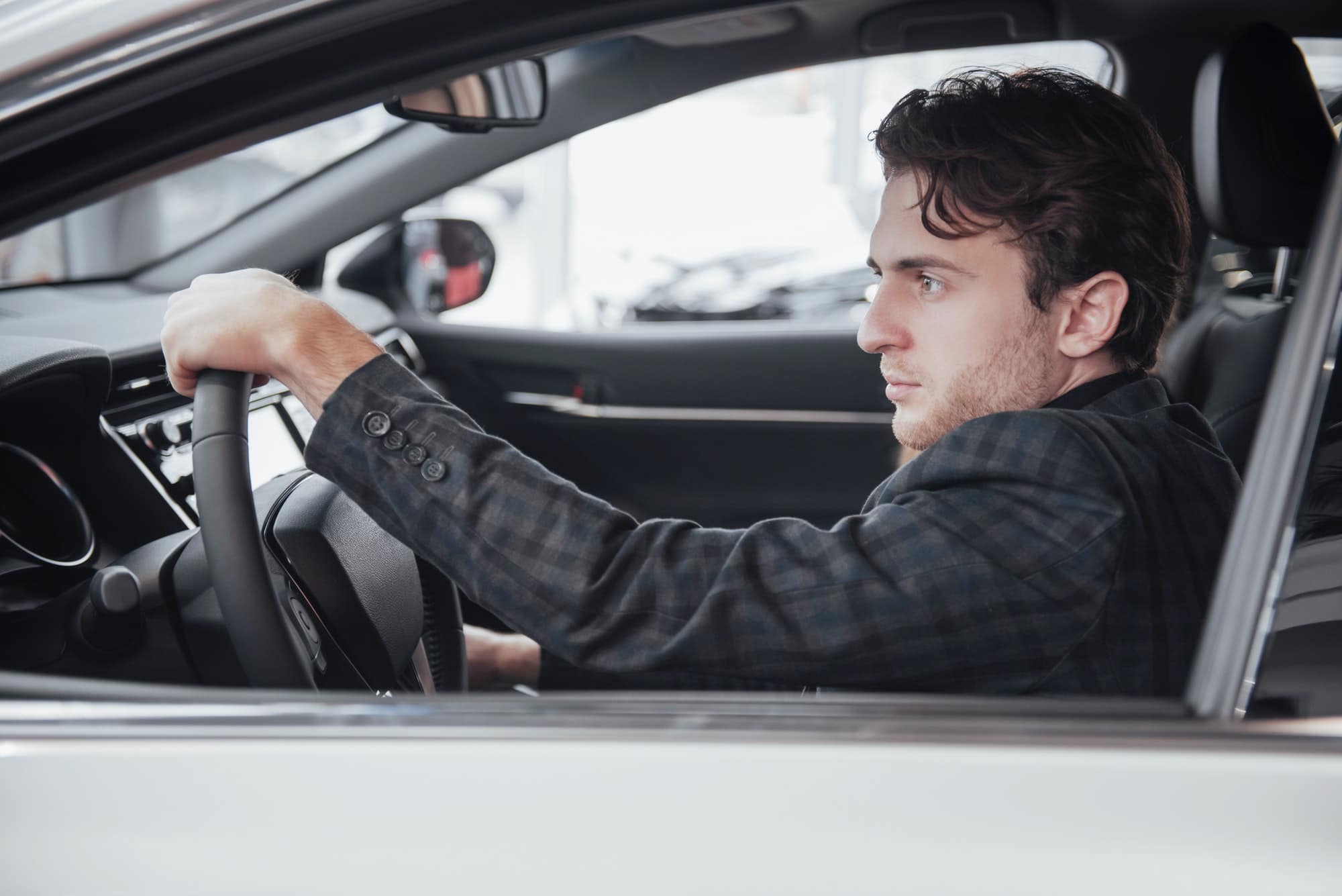 Ready for test drive. Portrait of a handsome businessman driving car