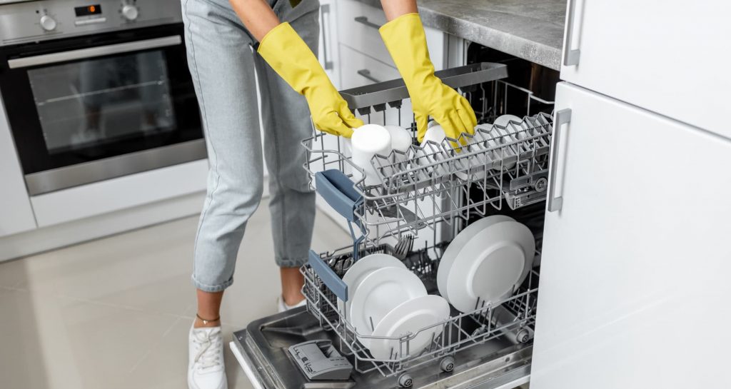 Woman loading dishes into the dishwasher machine