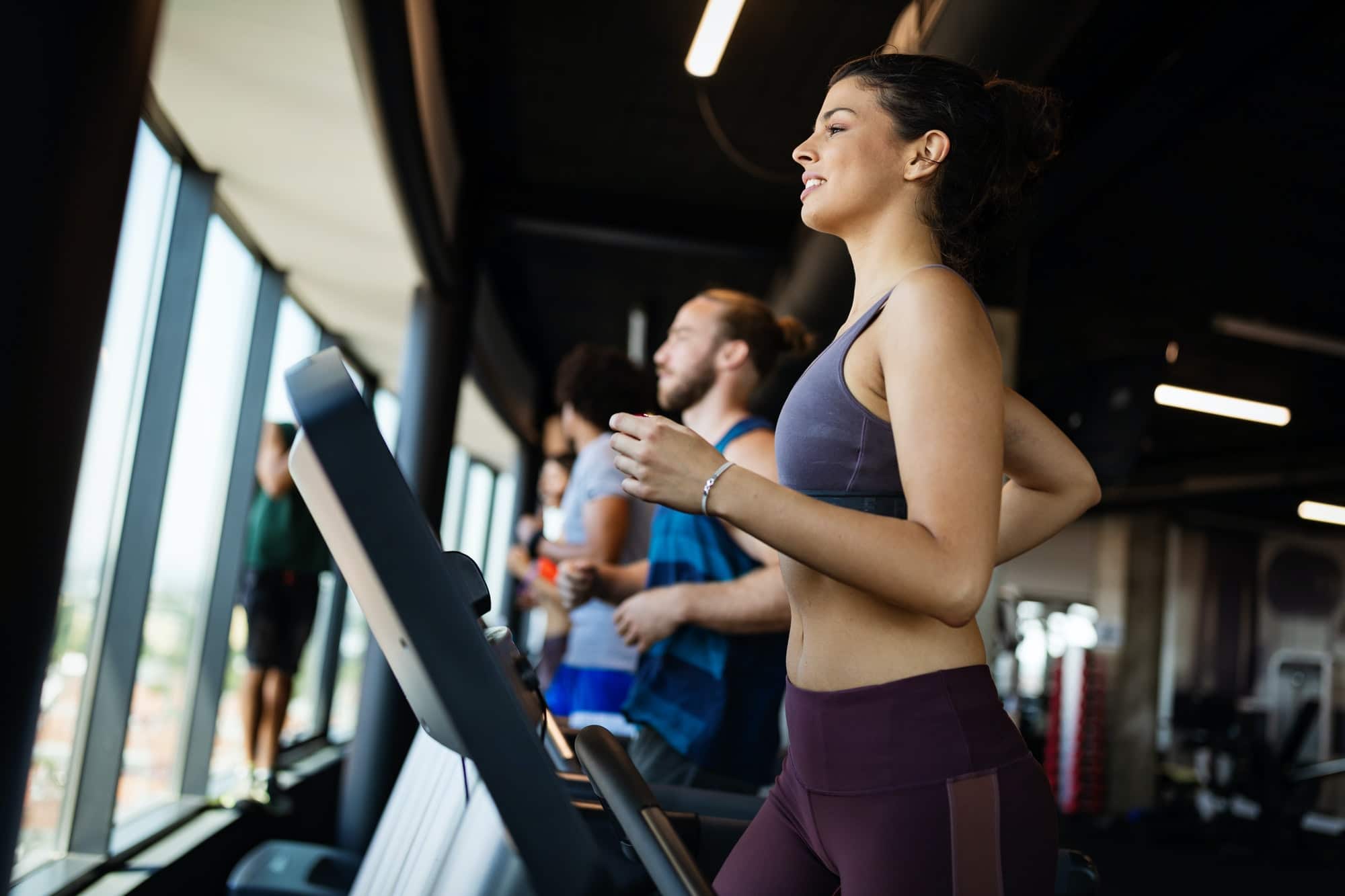 Fit group of people exercising on a treadmill in gym