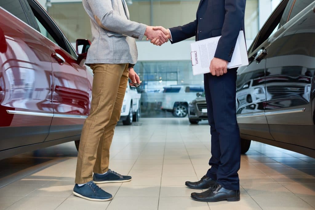 People Shaking Hands in Car Showroom