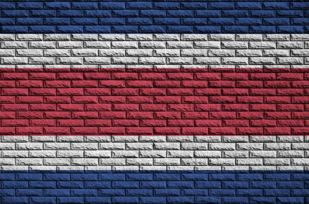 Costa Rica flag is painted onto an old brick wall