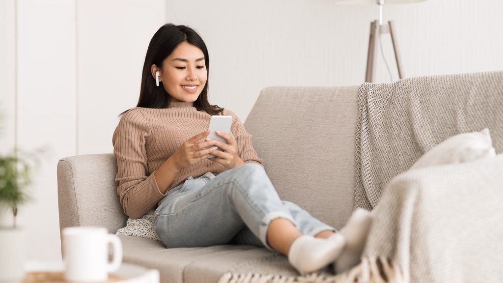 Millennial girl enjoying music online in airpods