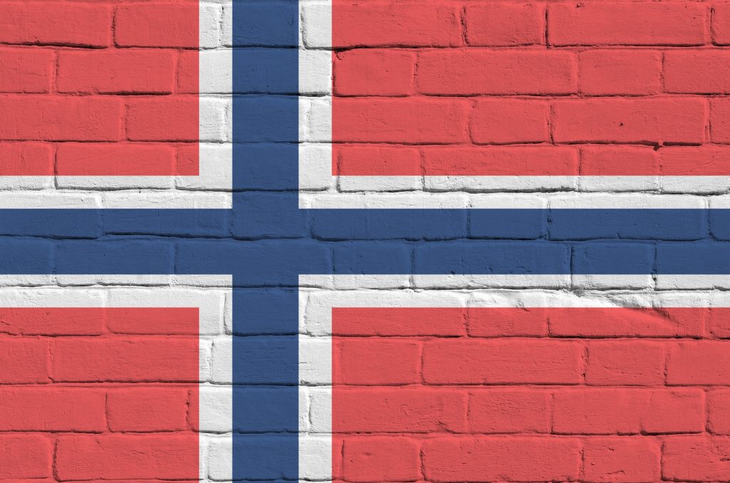 Norway flag depicted in paint colors on old brick wall close up