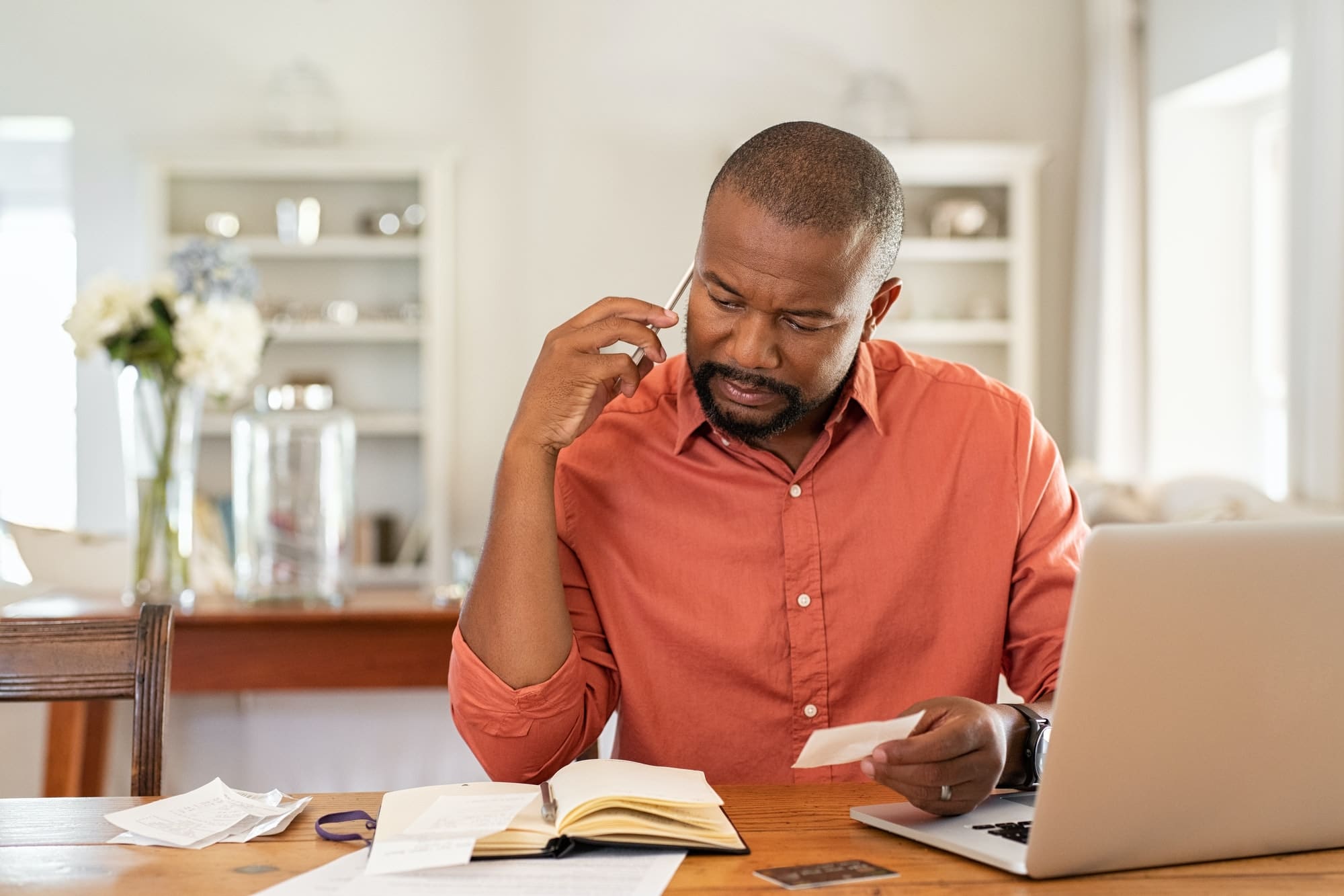 Worried man with bills call the bank