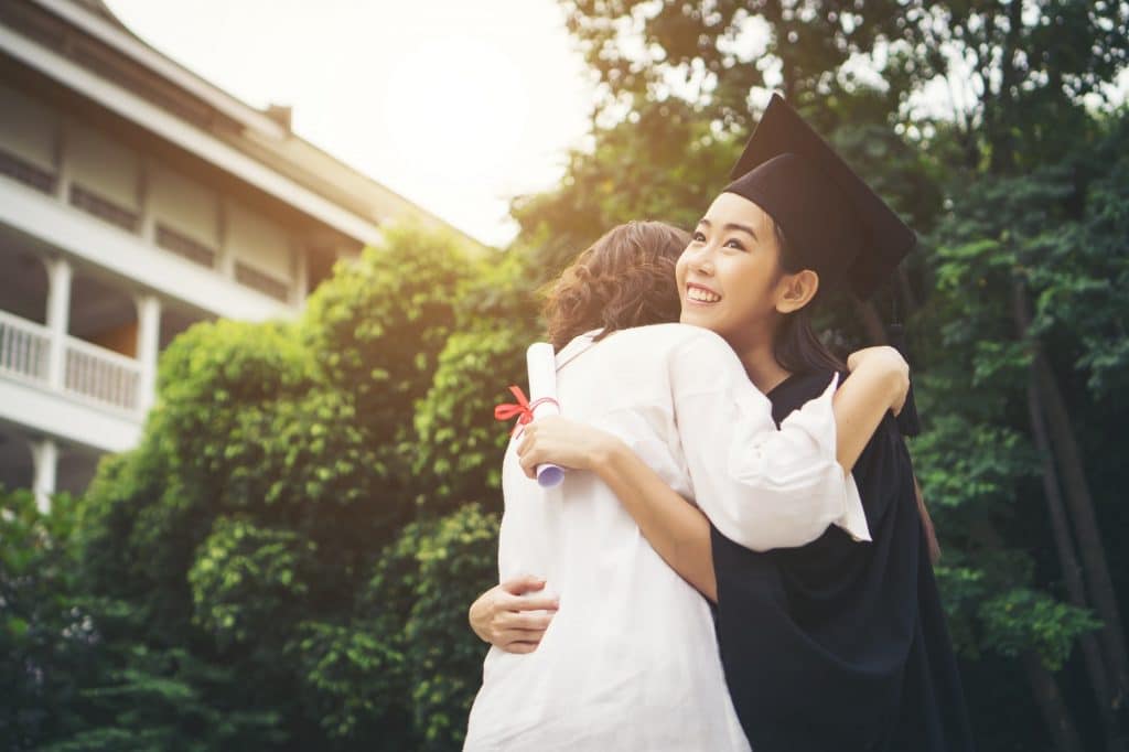 Young female graduate hugging her mother at graduation ceremony, Success,Goal. Education concept.