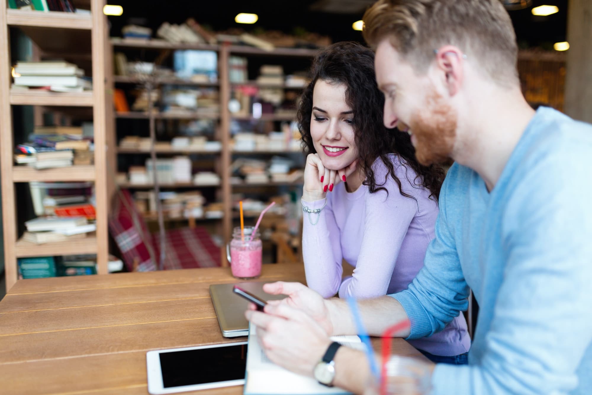 Attractive students learning together in coffee shop