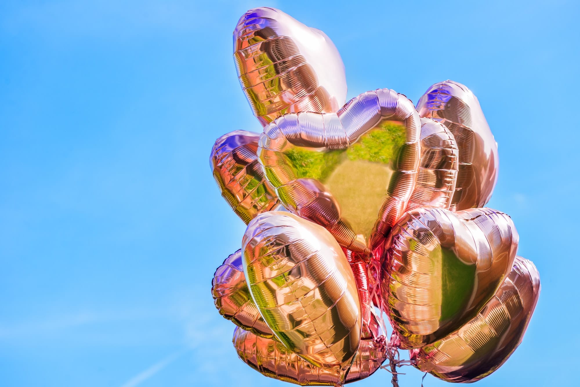 Bunch of Heart shaped ballons on the sky background