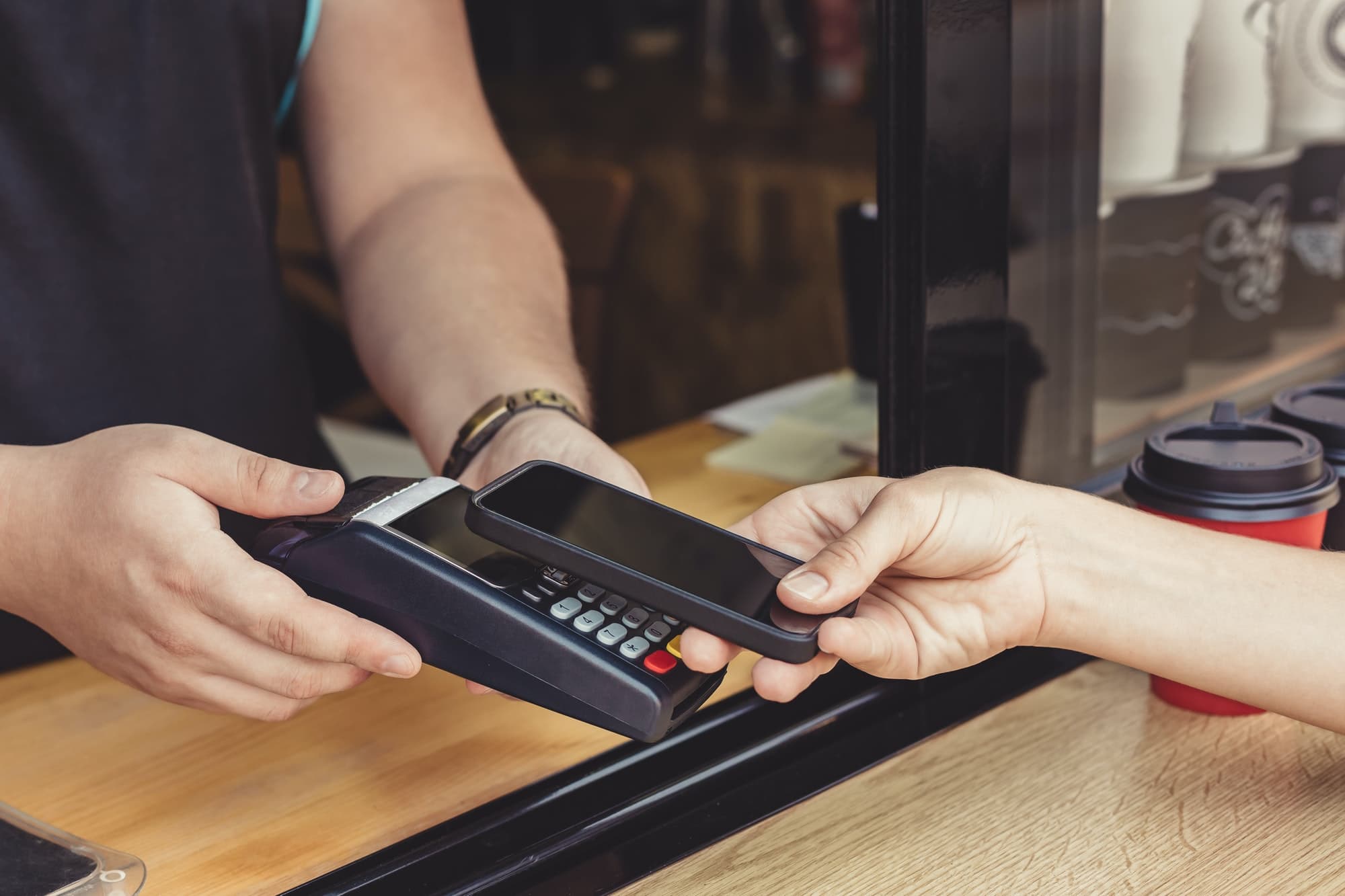 Person paying pay through smartphone using NFC