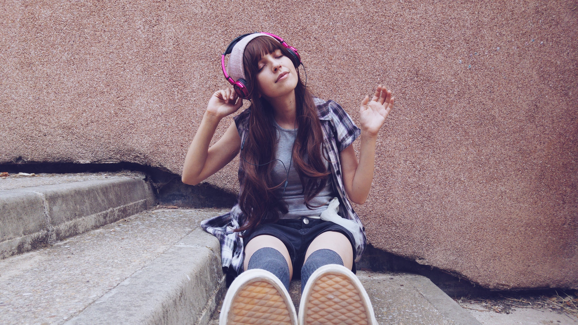 Young student woman listening to music in a park