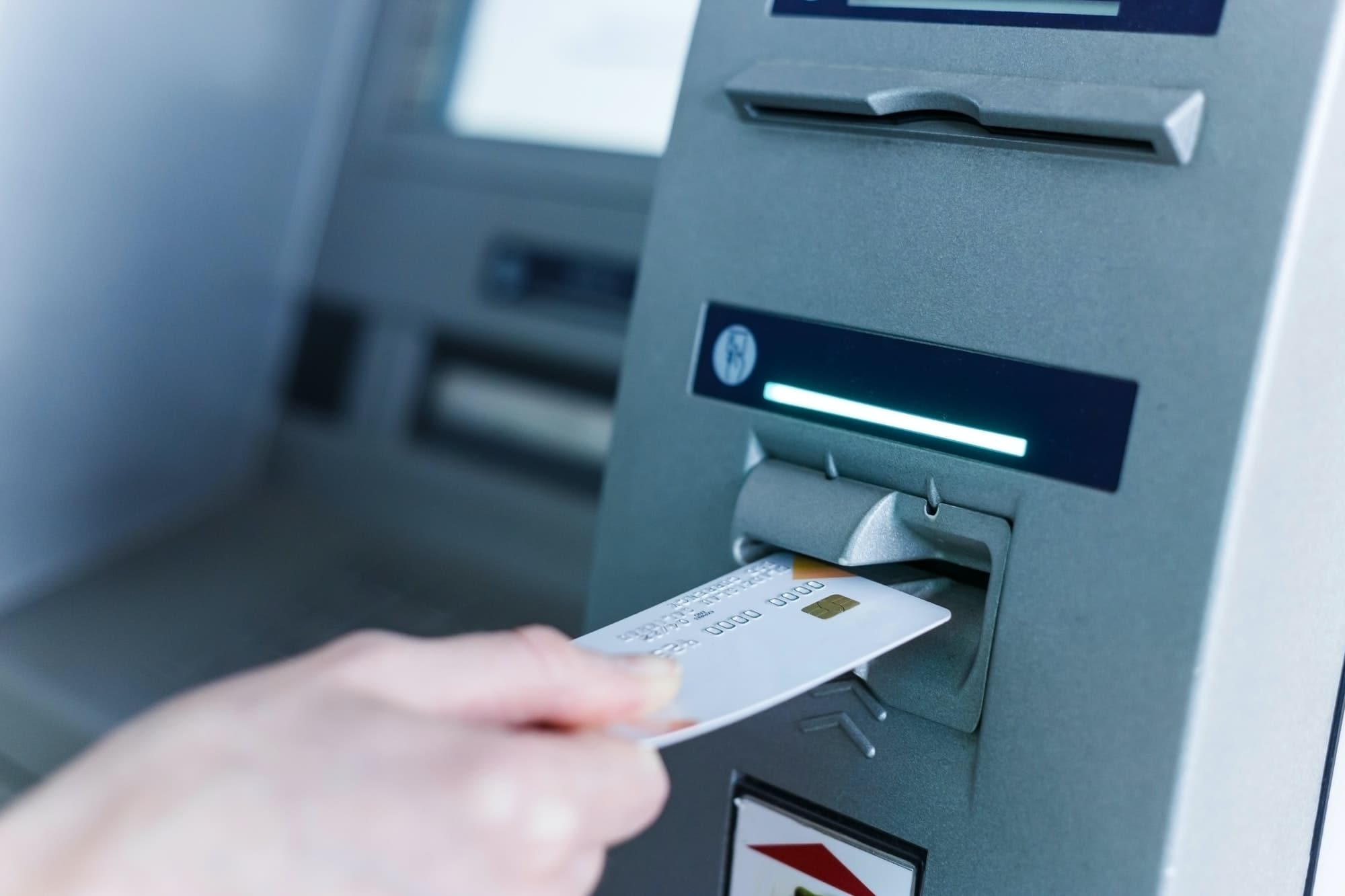 Person insert card to automated teller machine. Cashing non-cash money by individual.