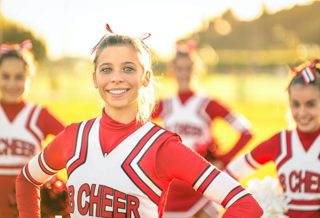 Portrait of an happy young cheerleader in action outdoors