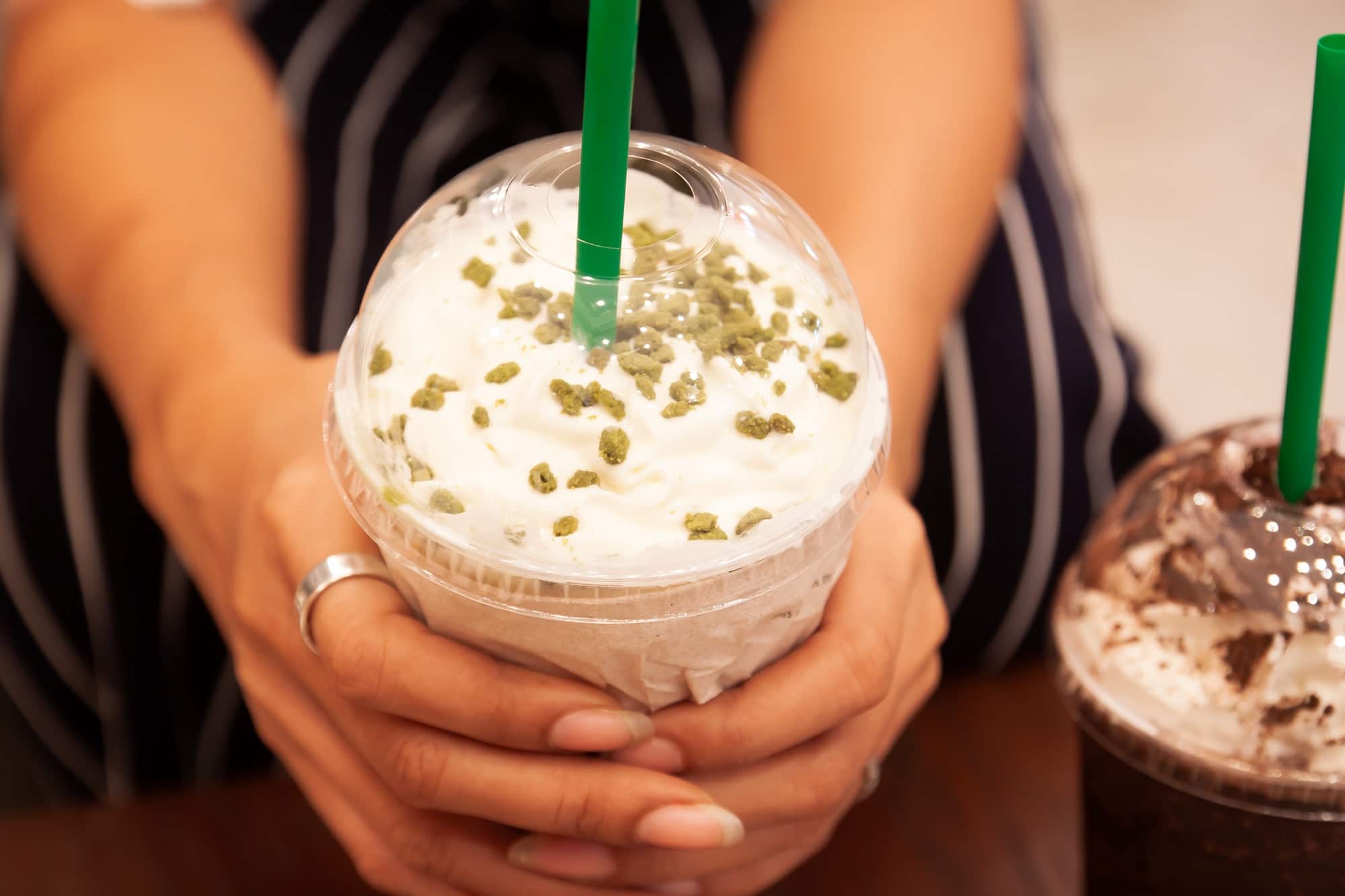 Starbucks Tea Ramisu Frappe with whipping cream in woman's hands