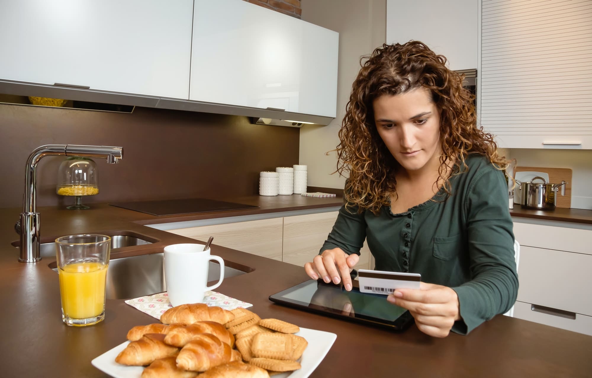 Woman with electronic tablet and credit card buying online