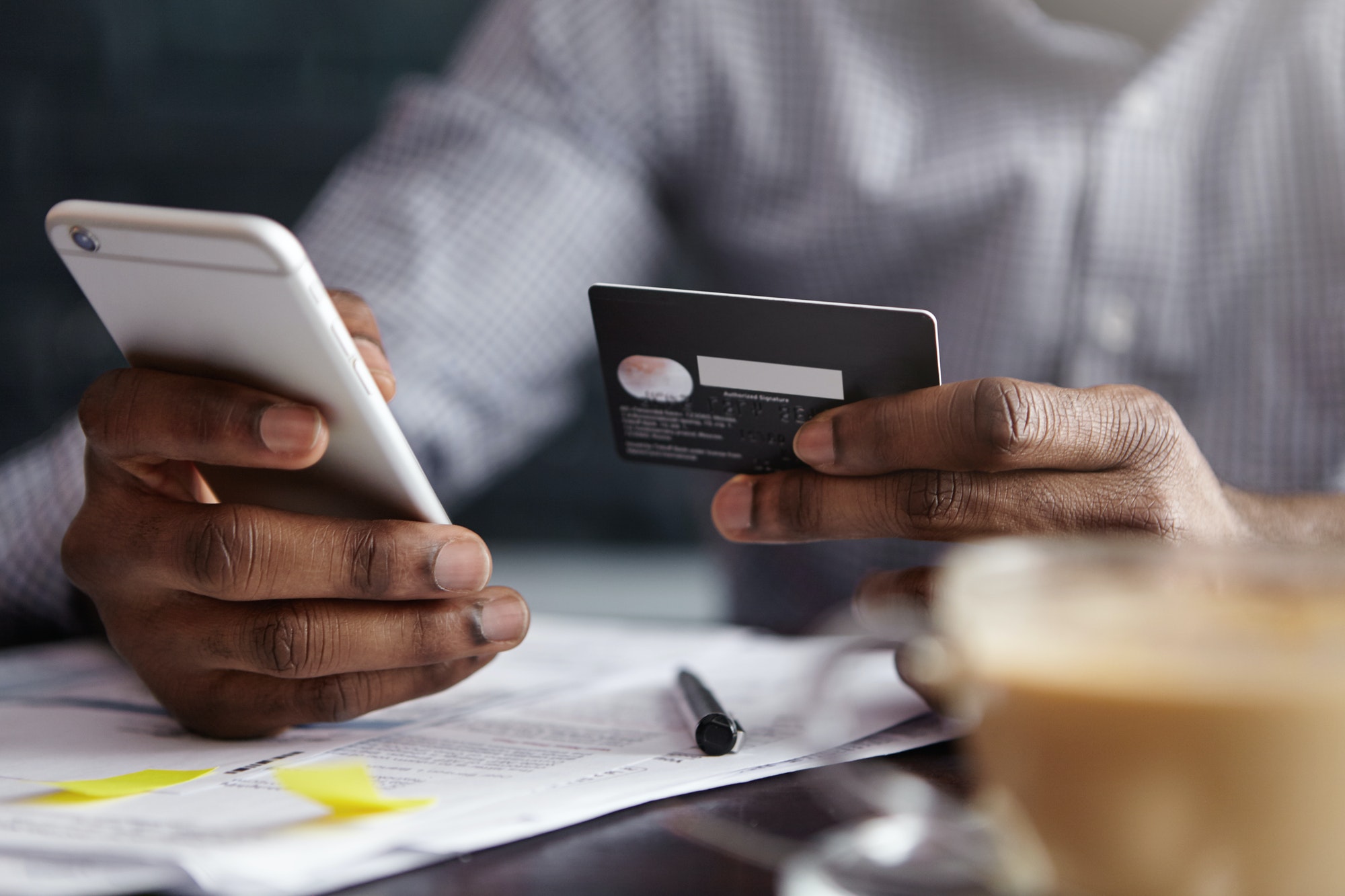 Cropped shot of African-American businessman paying with credit card online making orders via Intern