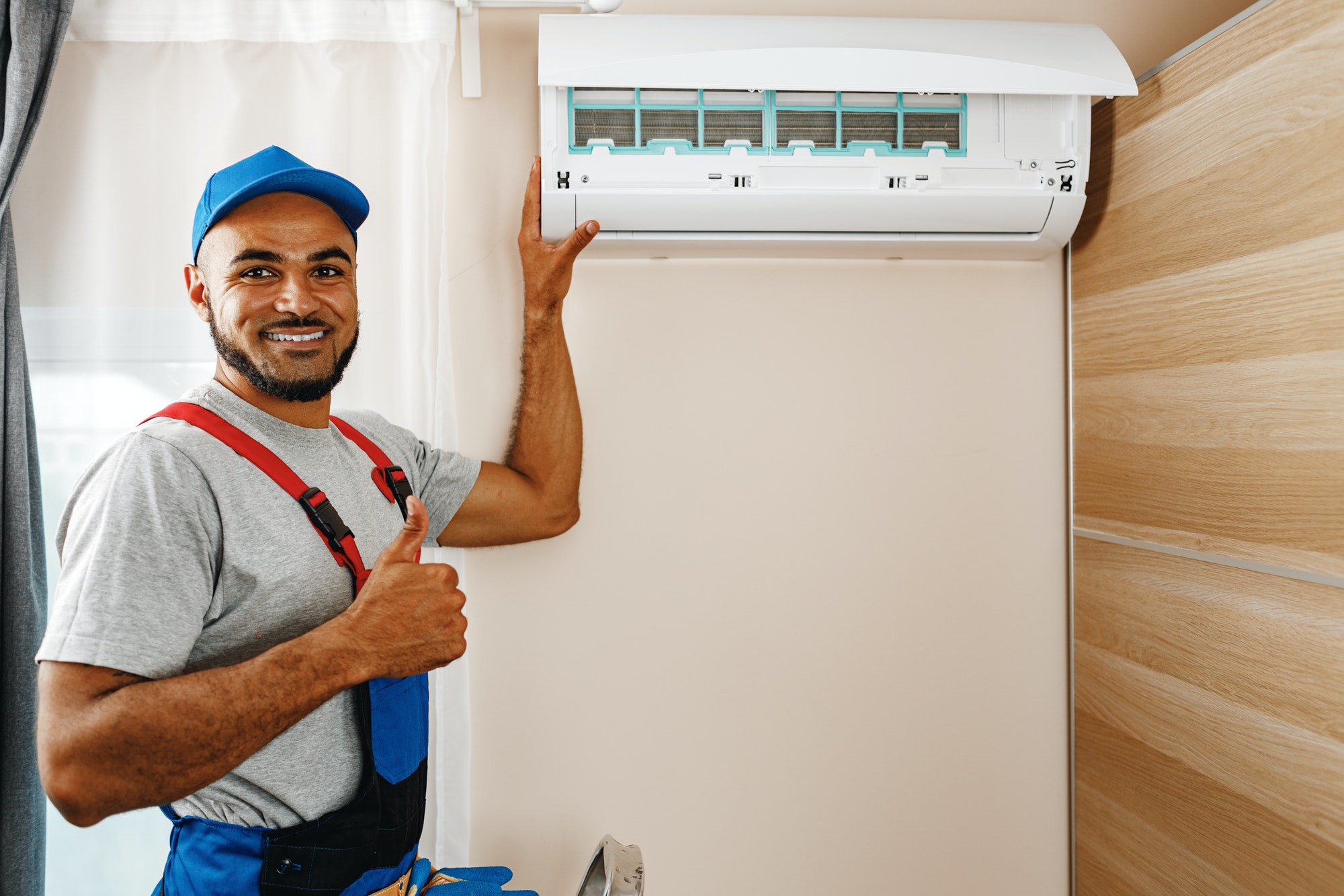 Professional repairman installing air conditioner in a room