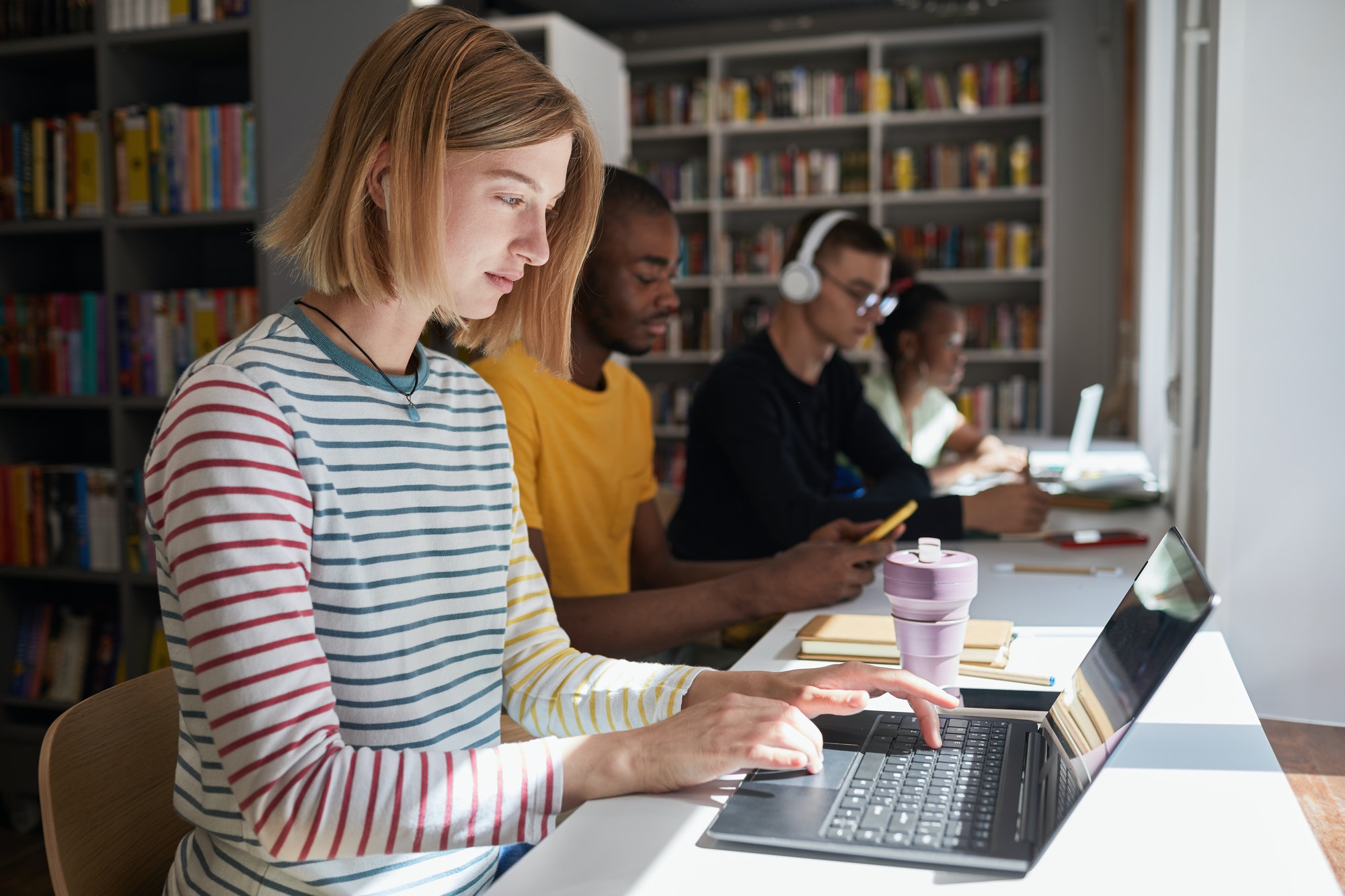 Young Woman using Laptop in Library