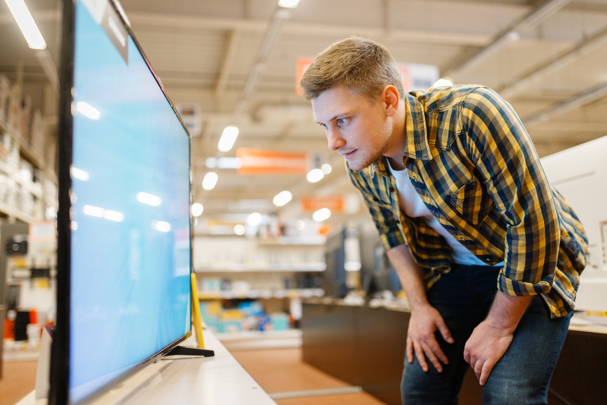 Man choosing TV in electronics store