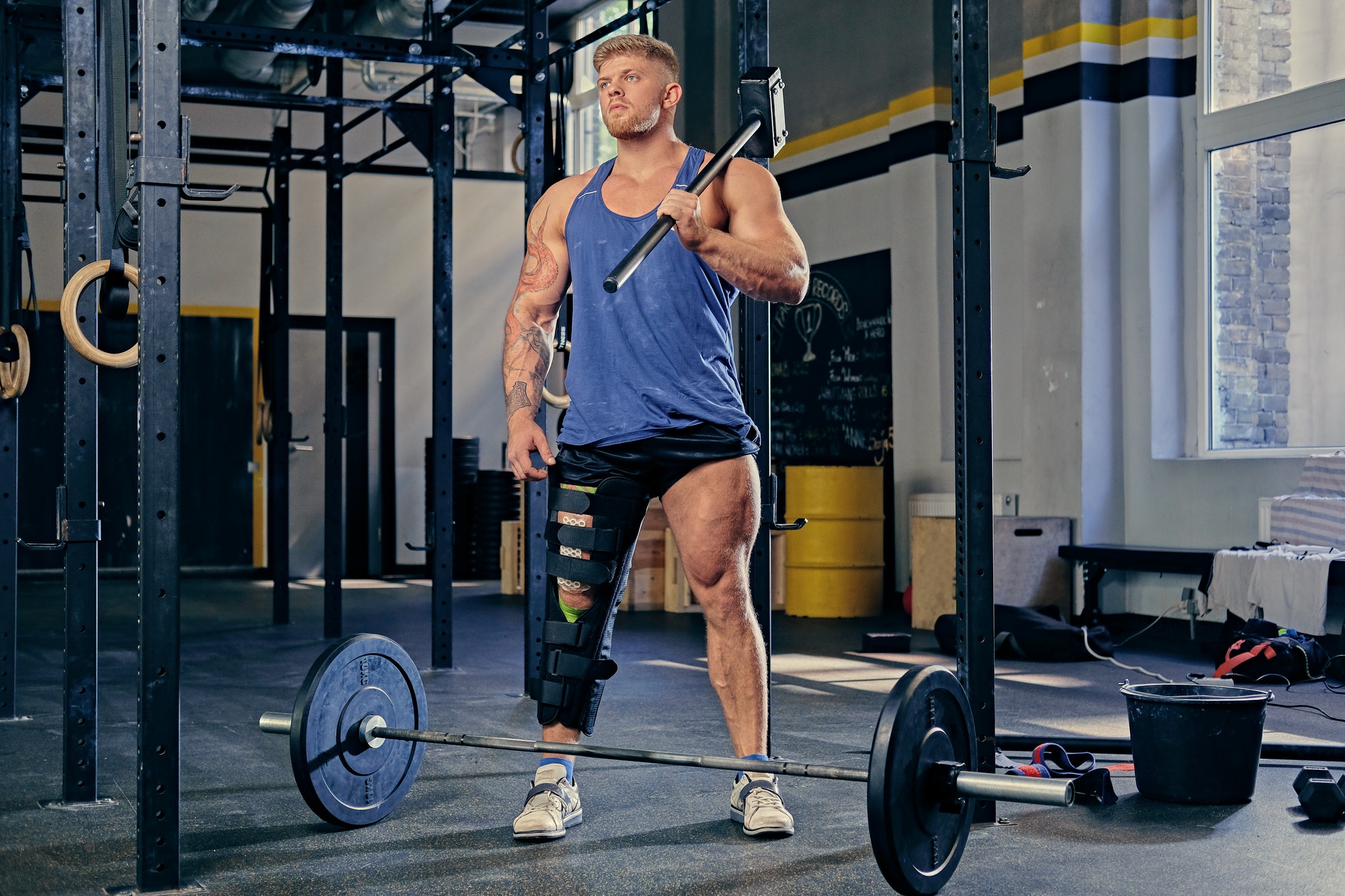 Bodybuilder holds cross fit hammer.