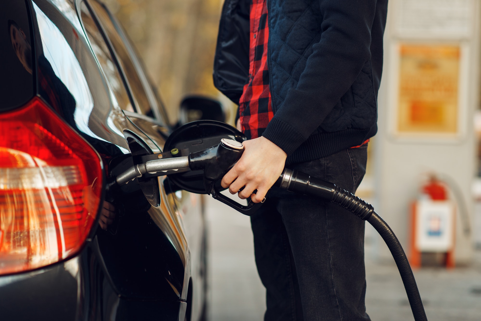 Man inserts the gun into the tank on gas station