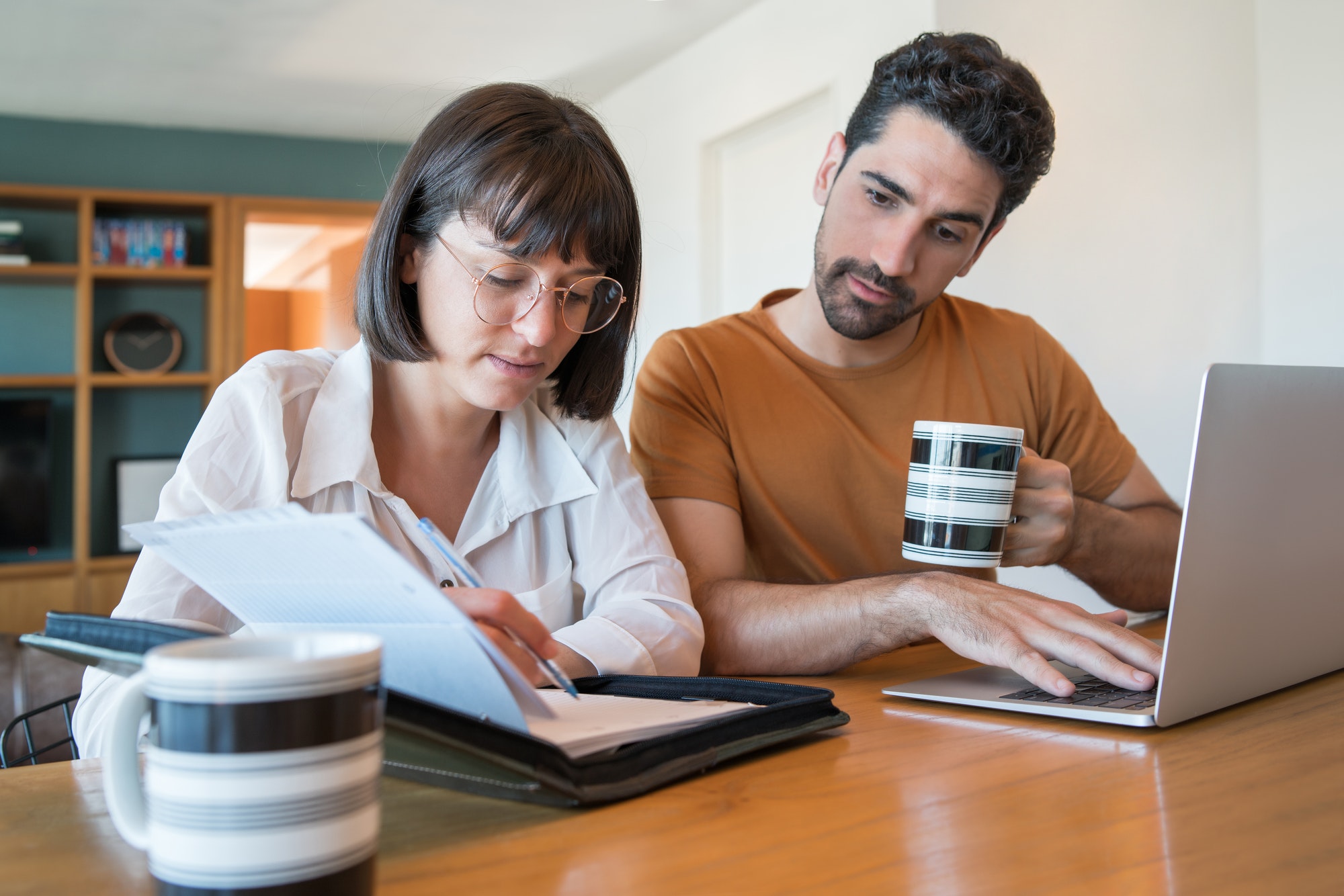 Young couple paying bills on laptop.