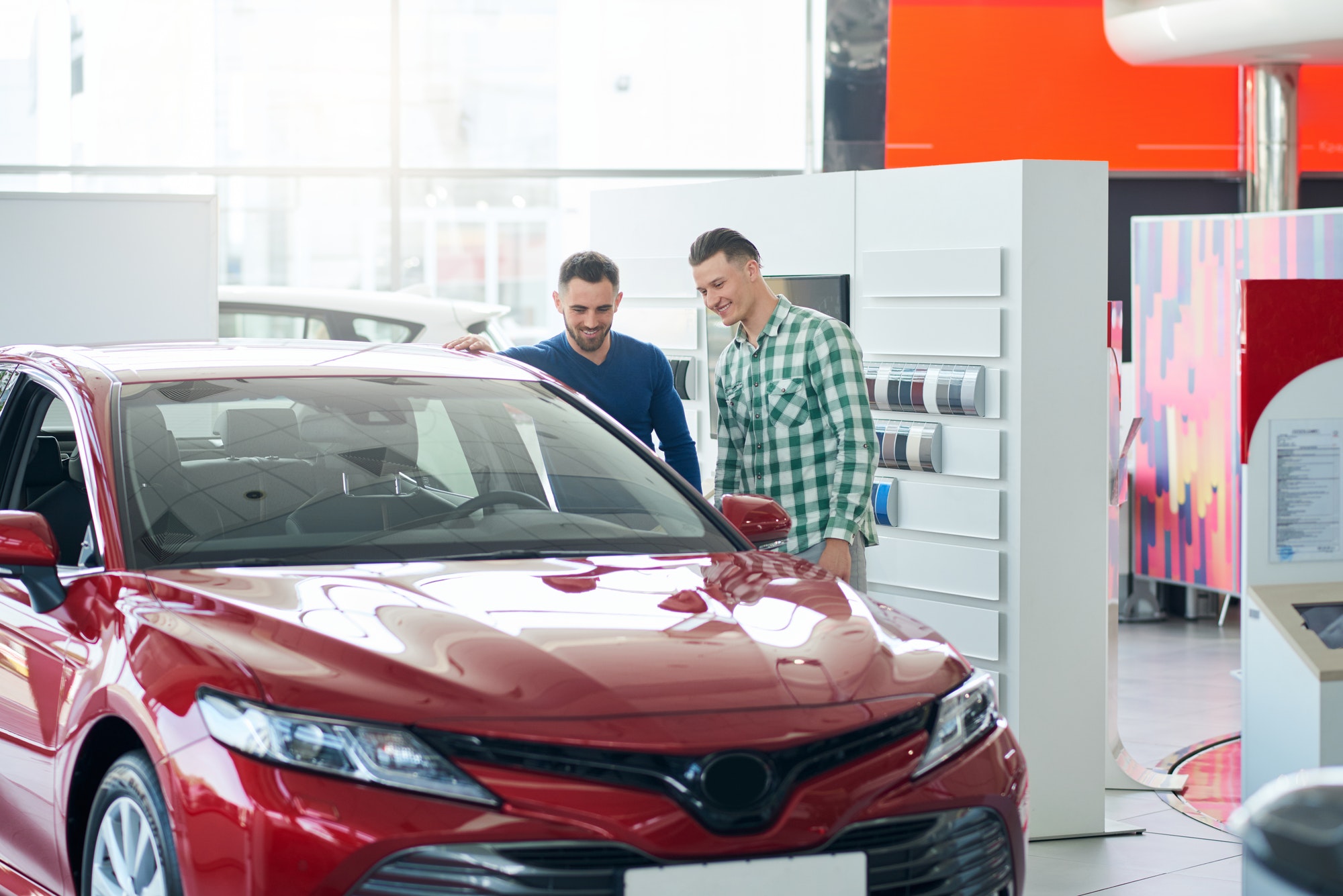 Car seller showing customer car in dealership